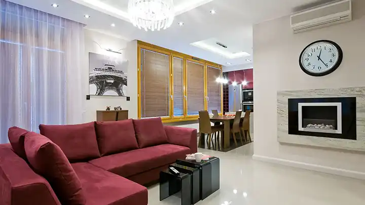 Nowoczesny salon z bordową sofą, żółtymi zasłonami i oświetleniem sufitowym