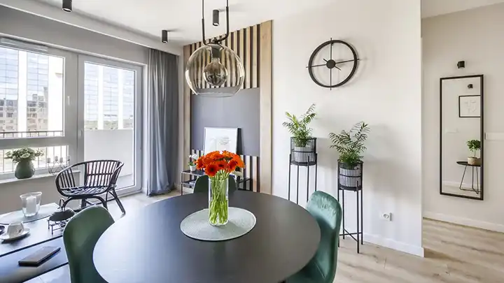 Nowoczesna jadalnia z okrągłym stołem i wazonem z kwiatami w jasnym wnętrzu