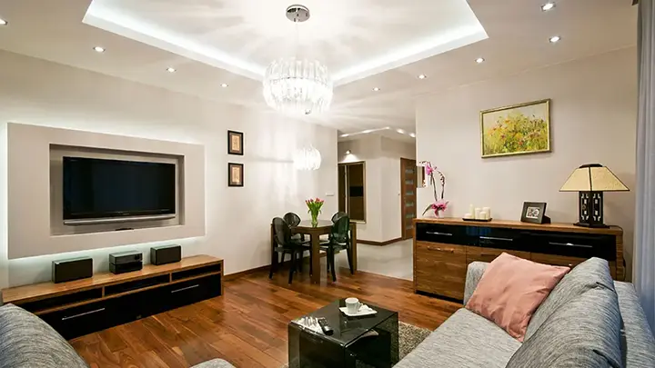 Salon z jadalnią, telewizorem i kryształowym oświetleniem sufitowym