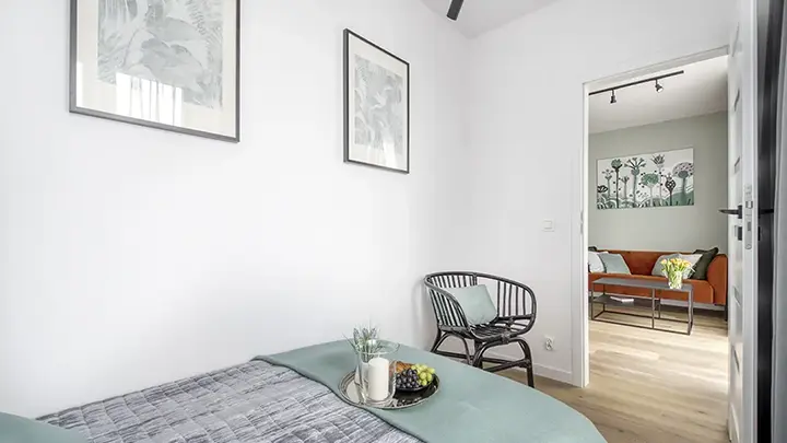 Jasna sypialnia z minimalistycznym wystrojem i grafitowym akcentem