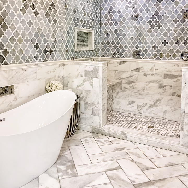 Luksusowa łazienka z wanną wolnostojącą i marmurowymi kafelkami w jodełkę.